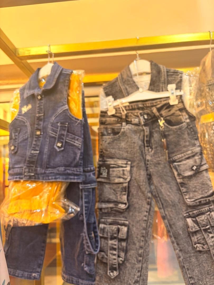 Sélection de vêtements enfant colorés présentée sur cintres